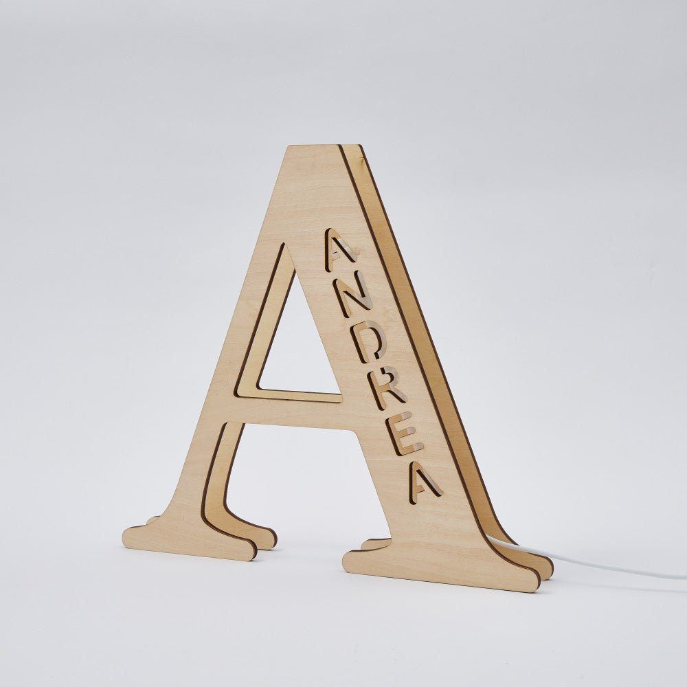 Personalized wooden letter 'A' night light with 'ANDREA' name, 28cm tall, emitting a warm LED glow, perfect for home decor.