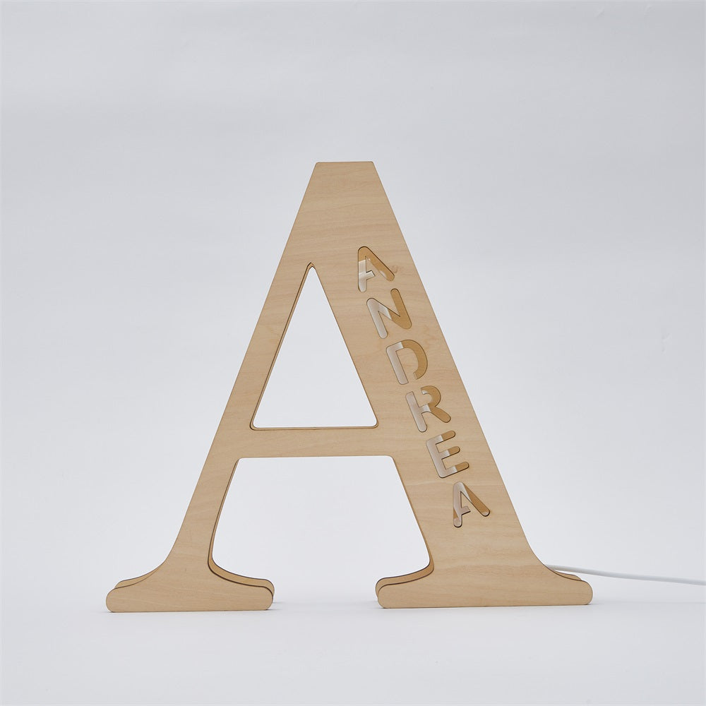 Personalized wooden letter 'A' night light with 'ANDREA', 28cm tall. Warm LED glow, unique home decor item.